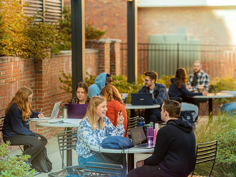 Students sitting at tables outside